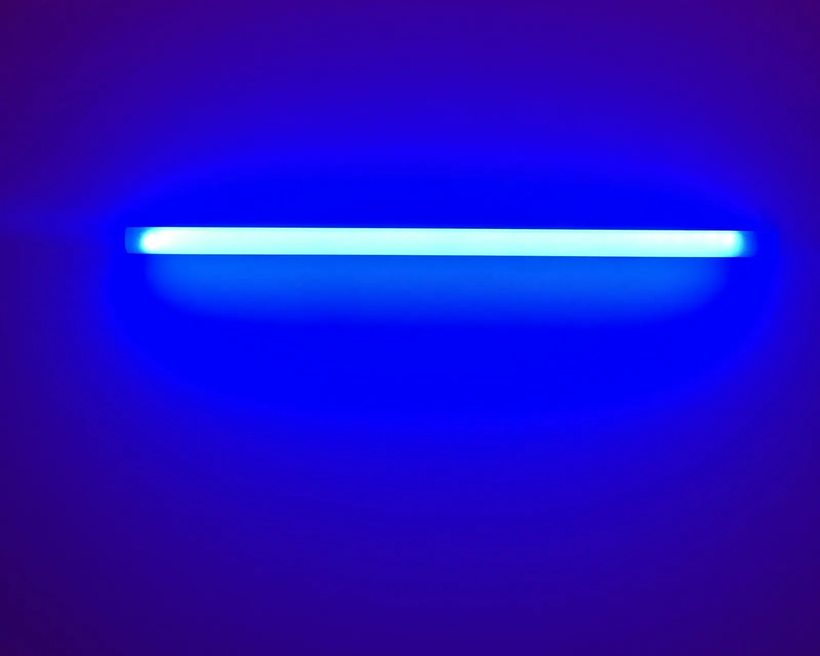 Glowing blue ultraviolet tube against a dark purple background
