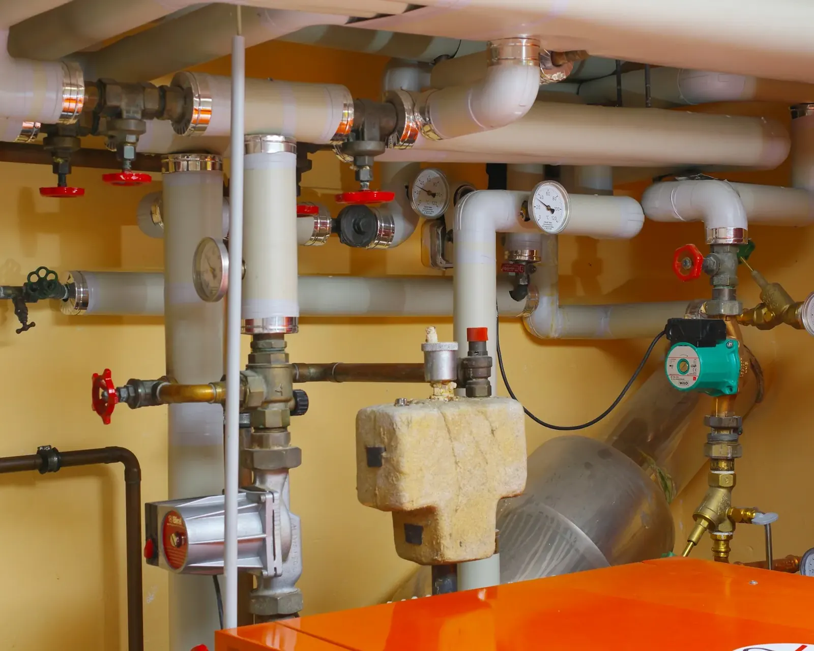 Basement plumbing manifold with pressure gauges and valves
