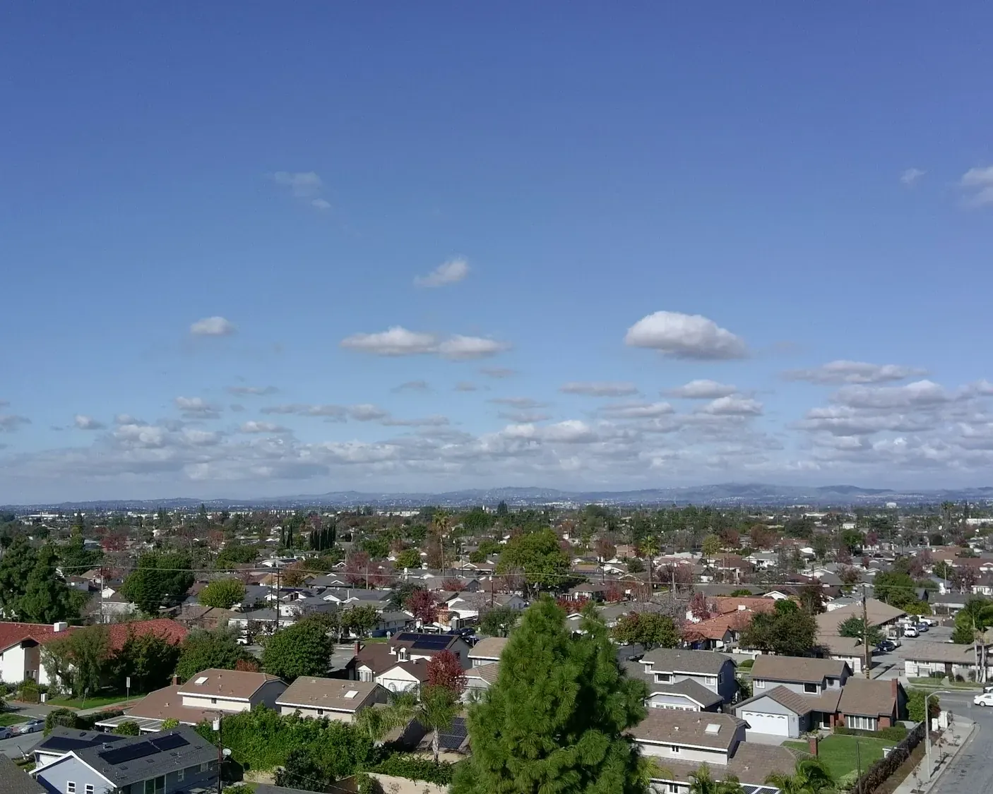 Aerial view of suburban neighborhoods under a wide blue sky
